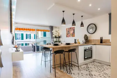 a kitchen with a counter and bar stools at 2-room apartment with terrace close to the center in Cannes