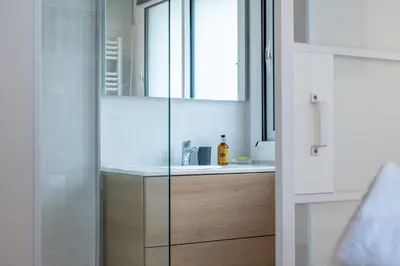 a bathroom with a sink and a glass shower at 2-room apartment with terrace close to the center in Cannes