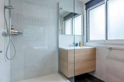 a bathroom with a glass shower and a sink at 2-room apartment with terrace close to the center in Cannes