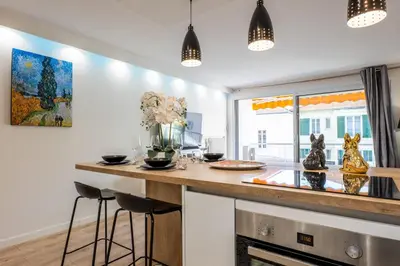 a kitchen with a bar with stools at a counter at 2-room apartment with terrace close to the center in Cannes
