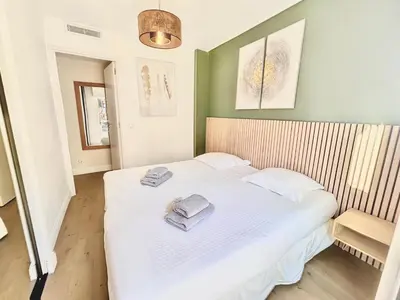 a bedroom with a white bed with towels on it at 2 BR Croisette balcony & sea view Olam Properties in Cannes