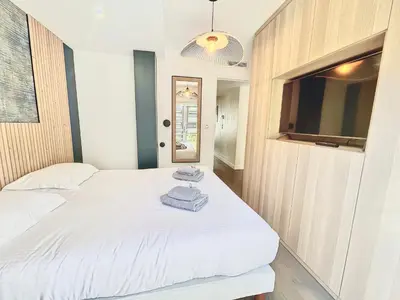 a bedroom with two beds and a flat screen tv at 2 BR Croisette balcony & sea view Olam Properties in Cannes