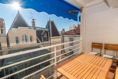 a balcony with a bench and a view of the city at 2 BR Croisette balcony & sea view Olam Properties in Cannes