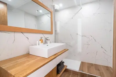 a white bathroom with a sink and a mirror at 2 BR Croisette balcony & sea view Olam Properties in Cannes
