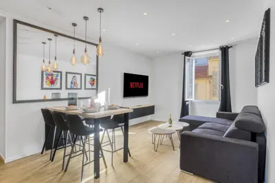 a living room with a table and a couch at 3 chambres Modern - 2 min du Palais - Climatisé - Calme in Cannes