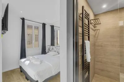 a small bedroom with a bed and a shower at 3 chambres Modern - 2 min du Palais - Climatisé - Calme in Cannes