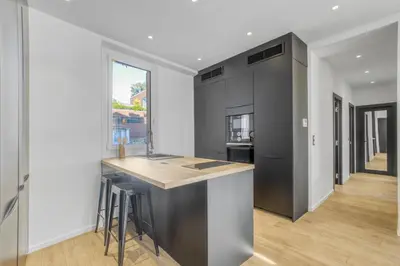 a kitchen with a island in the middle of a room at 3 chambres Modern - 2 min du Palais - Climatisé - Calme in Cannes