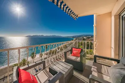 a balcony with a couch and a view of the ocean at Wonderful 2 bedroom apartment with sea view in Cannes
