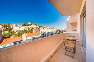 a stool on a balcony with a view of a city at Wonderful 2 bedroom apartment with sea view in Cannes