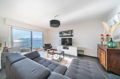 a living room with a couch and a tv at Wonderful 2 bedroom apartment with sea view in Cannes