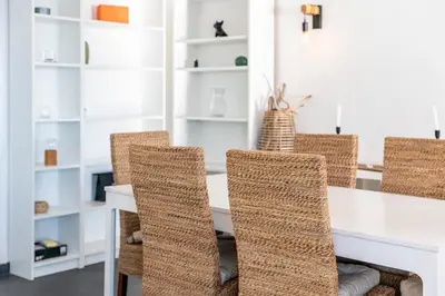 a dining room with a white table and wicker chairs at Wonderful 2 bedroom apartment with sea view in Cannes