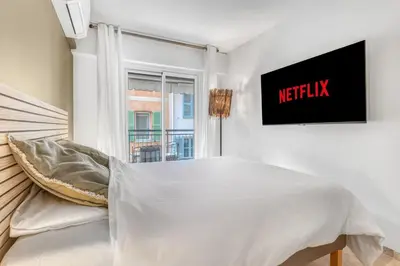 a white bedroom with a bed and a window at 1 Chambre - Ascenseur - Spacieux - Proche palais in Cannes