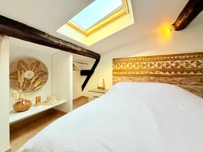 a bedroom with a white bed and a skylight at Charmant Appartement à 50m du Palais des Festivals et de la Croisette in Cannes