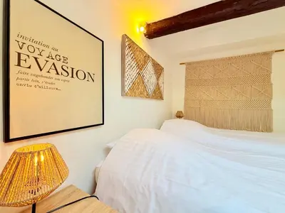 a bedroom with a bed and a poster on the wall at Charmant Appartement à 50m du Palais des Festivals et de la Croisette in Cannes