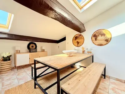 a dining room with a wooden table and benches at Charmant Appartement à 50m du Palais des Festivals et de la Croisette in Cannes