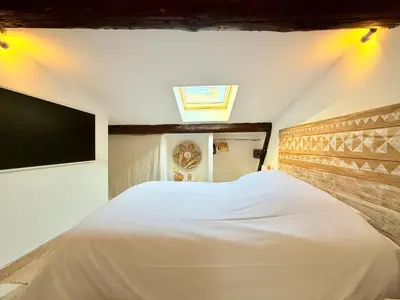 a bedroom with a white bed and a tv at Charmant Appartement à 50m du Palais des Festivals et de la Croisette in Cannes