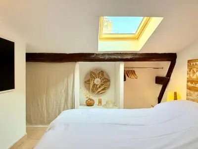 a bedroom with a white bed with a window at Charmant Appartement à 50m du Palais des Festivals et de la Croisette in Cannes