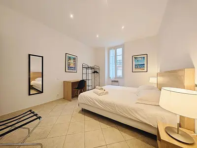 a bedroom with a large bed and a desk at Viva Riviera 11 rue Commandant André in Cannes