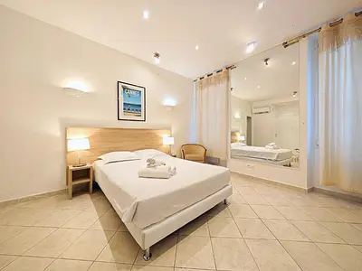 a bedroom with a large bed and a bathroom at Viva Riviera 11 rue Commandant André in Cannes