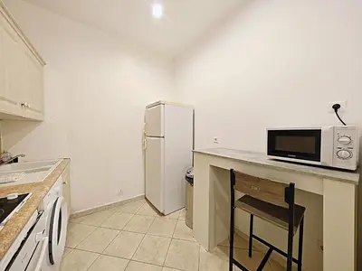 a kitchen with a counter with a microwave and a refrigerator at Viva Riviera 11 rue Commandant André in Cannes