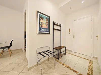 a room with a chair and a mirror on a wall at Viva Riviera 11 rue Commandant André in Cannes