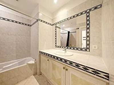 a bathroom with a sink and a tub and a mirror at Viva Riviera 11 rue Commandant André in Cannes