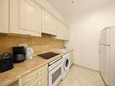 a kitchen with white cabinets and a washer and dryer at Viva Riviera 11 rue Commandant André in Cannes