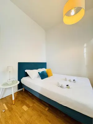 a bedroom with a white bed with a blue headboard at Studio chaleureux proche croisette Mimont29 in Cannes
