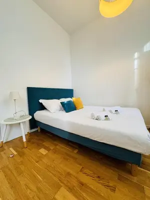 a bedroom with a bed with a blue headboard at Studio chaleureux proche croisette Mimont29 in Cannes