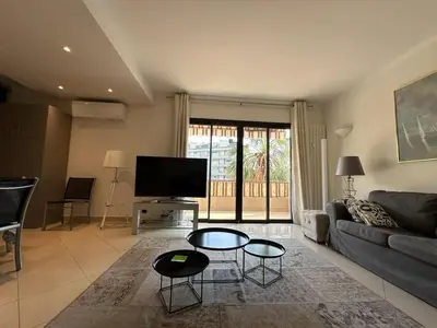 a living room with a couch and a tv at A003-Magnifique appartement proche du centre de Cannes in Cannes