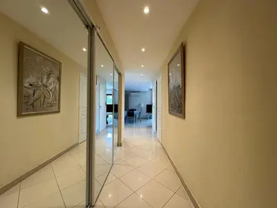 a hallway with glass doors and paintings on the walls at A003-Magnifique appartement proche du centre de Cannes in Cannes