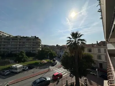 a view of a street with a palm tree and buildings at A003-Magnifique appartement proche du centre de Cannes in Cannes