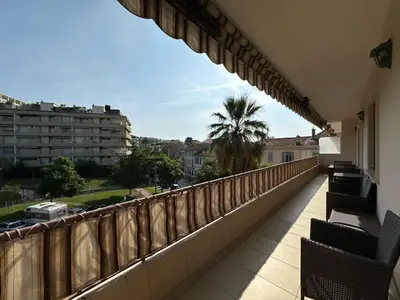 a balcony with chairs and a view of a city at A003-Magnifique appartement proche du centre de Cannes in Cannes
