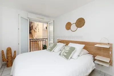 a white bedroom with a large white bed with pillows at Palazzio RE in Cannes