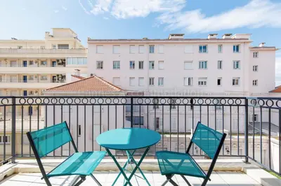 a table and chairs on a balcony with buildings at Palazzio RE in Cannes