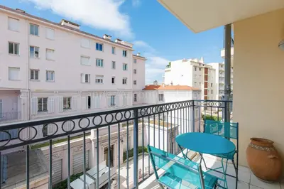 a balcony with a blue chair and a table on it at Palazzio RE in Cannes
