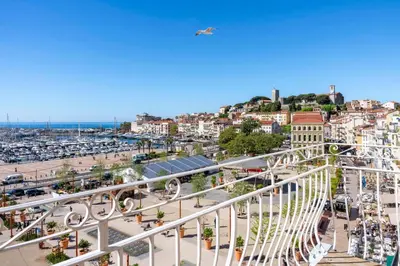an aerial view of a city with a plane flying overhead at REF 1926 - Cannes Center - Sea view apartment for rent in Cannes