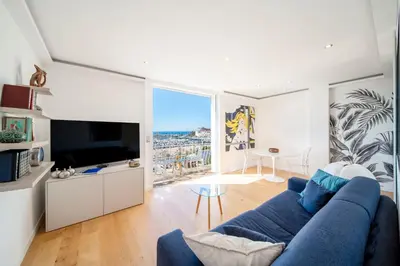a living room with a blue couch and a tv at REF 1926 - Cannes Center - Sea view apartment for rent in Cannes