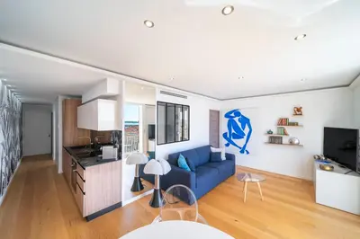 a living room with a blue couch and a kitchen at REF 1926 - Cannes Center - Sea view apartment for rent in Cannes