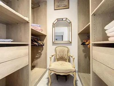 a chair in a walk in closet with a mirror at Cannes - 3 pieces a 15mn Palais in Cannes