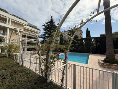 a white fence next to a swimming pool at Cannes - 3 pieces a 15mn Palais in Cannes