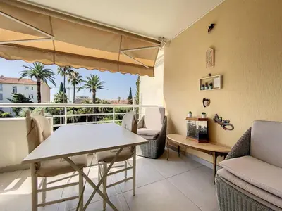 a living room with a table and chairs and a balcony at Cannes - 3 pieces a 15mn Palais in Cannes