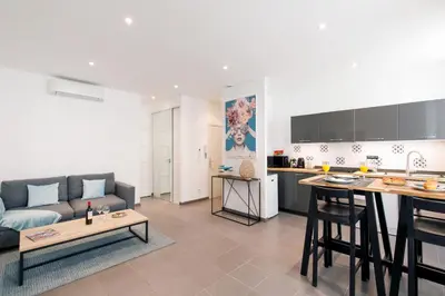 a living room with a couch and a kitchen at Vagliano Standing Presta in Cannes