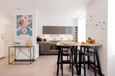 a kitchen with a table and some chairs in it at Vagliano Standing Presta in Cannes