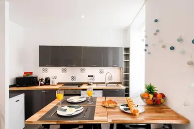 a kitchen with a wooden table with food on it at Vagliano Standing Presta in Cannes