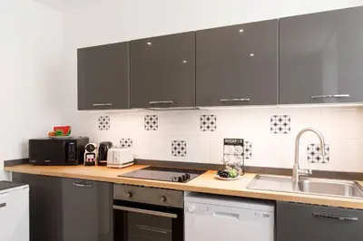 a kitchen with black cabinets and a sink at Vagliano Standing Presta in Cannes