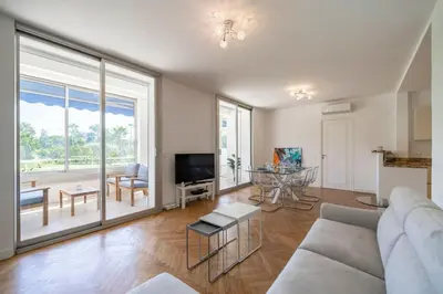 a living room with a couch and a large window at Cozystay 1331 - 4-bedroom apartment La Croisette in Cannes