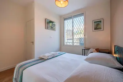 a bedroom with a large white bed with a window at Cozystay 1331 - 4-bedroom apartment La Croisette in Cannes