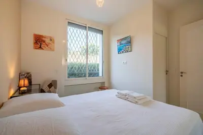 a bedroom with a white bed and a window at Cozystay 1331 - 4-bedroom apartment La Croisette in Cannes