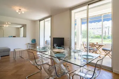 a dining room with a glass table and chairs at Cozystay 1331 - 4-bedroom apartment La Croisette in Cannes